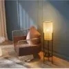 Nowoczesna lampa biurkowa z rattanu i metalu w cylindrycznym kształcie na nóżkach
