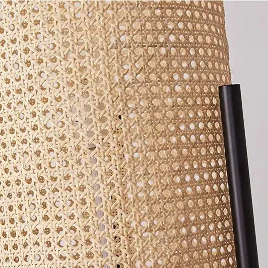 Nowoczesna lampa biurkowa z rattanu i metalu w cylindrycznym kształcie na nóżkach