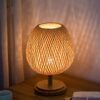 Okrągła lampka nocna z rattanu z drewnianą podstawą